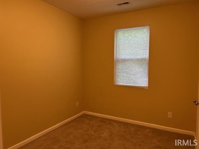 1221 N Lindbergh Dr, Bloomington, IN 47404 - spare room with dark colored carpet and baseboards