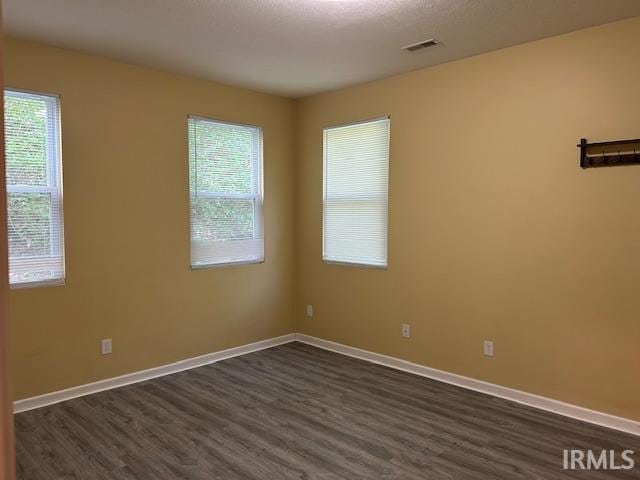 1221 N Lindbergh Dr, Bloomington, IN 47404 - spare room featuring dark wood-style flooring, baseboards, and plenty of natural light