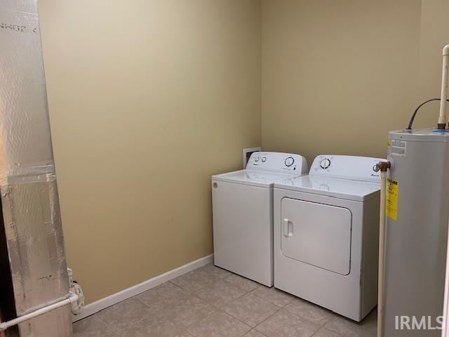 1221 N Lindbergh Dr, Bloomington, IN 47404 - laundry room with water heater, washer and clothes dryer, light tile patterned flooring, and baseboards