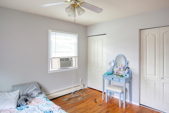 1818 Chochtimar Trl, Fort Wayne, IN 46808 - bedroom featuring a baseboard radiator, two closets, cooling unit, wood finished floors, and a ceiling fan