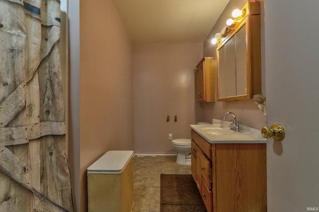 bathroom with toilet, baseboards, and vanity