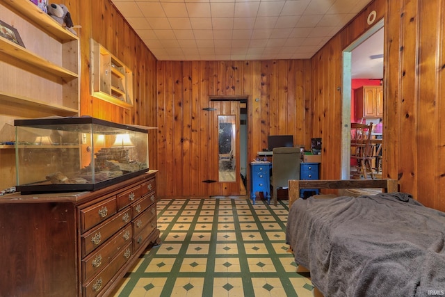 bedroom featuring light flooring and wood walls