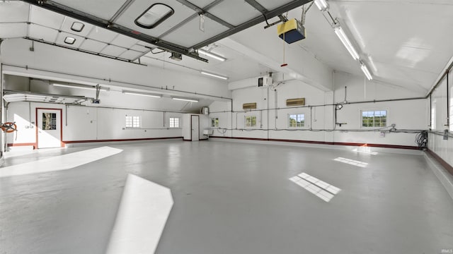 garage featuring a garage door opener and baseboards