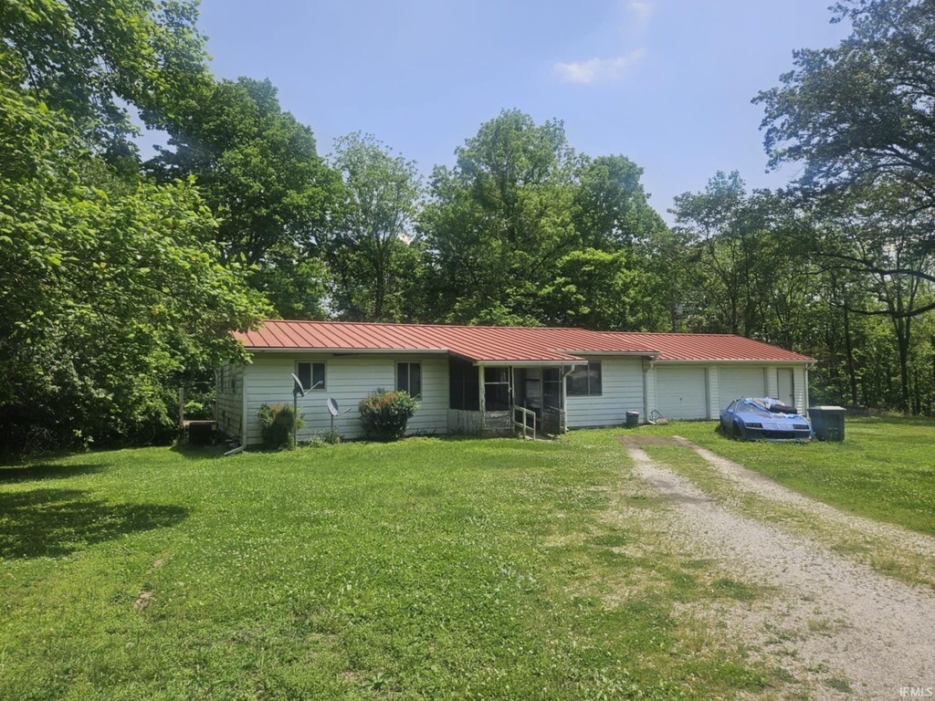 303 S 1st St, Edwardsport, IN 47528 - ranch-style house featuring driveway, a front yard, metal roof, and a garage