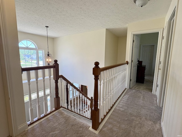 1804 Canyon Creek Dr, Lafayette, IN 47909 - corridor featuring an upstairs landing, carpet floors, a chandelier, and a textured ceiling