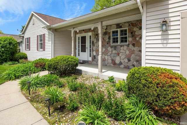 property entrance with covered porch and stone siding