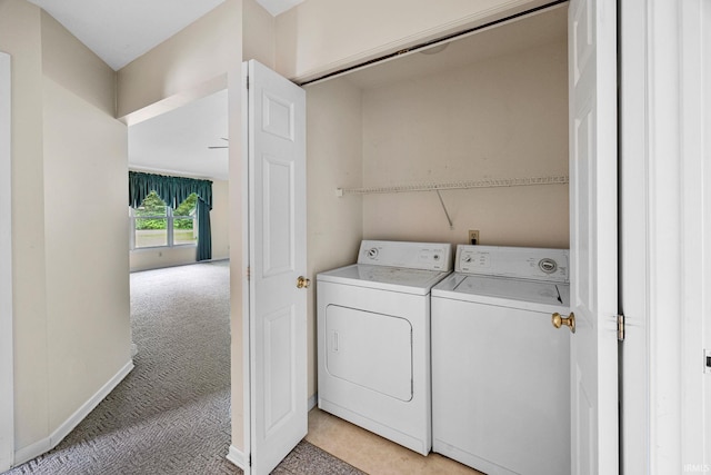 laundry area with washer and dryer, light carpet, and baseboards