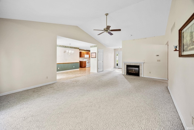 unfurnished living room featuring a ceiling fan, light colored carpet, a fireplace, a chandelier, and high vaulted ceiling