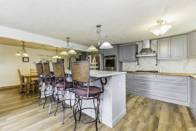11009 S County Road 300 W, Muncie, IN 47302 - kitchen with gray cabinetry, stainless steel appliances, light wood-type flooring, wall chimney range hood, and tasteful backsplash
