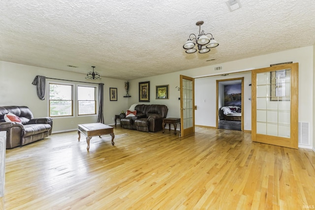 11009 S County Road 300 W, Muncie, IN 47302 - living area with a chandelier, light wood finished floors, a textured ceiling, french doors, and baseboards