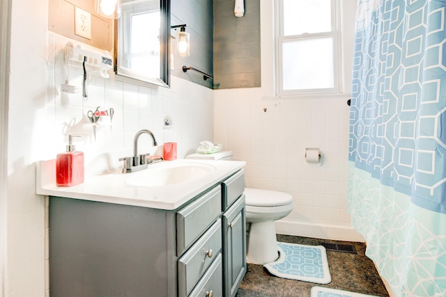1409 Main St, Vincennes, IN 47591 - bathroom with plenty of natural light, toilet, vanity, tile walls, and a shower with shower curtain
