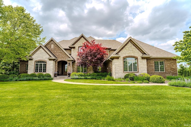 5198 Gardenia Ct, West Lafayette, IN 47906 - french country home with stone siding, a front yard, and roof with shingles