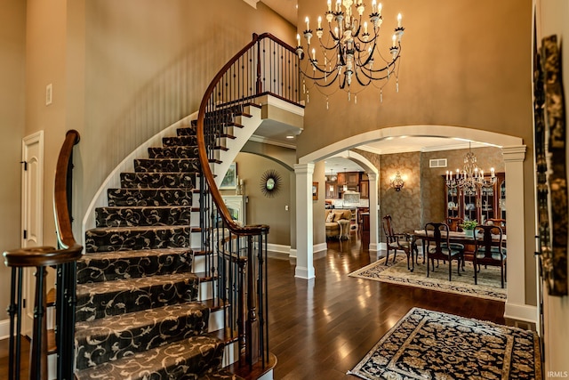 5198 Gardenia Ct, West Lafayette, IN 47906 - stairs with a chandelier, a high ceiling, arched walkways, hardwood / wood-style flooring, and baseboards