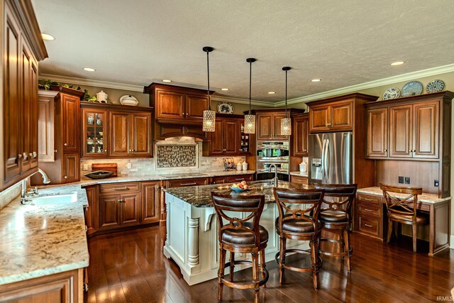 5198 Gardenia Ct, West Lafayette, IN 47906 - kitchen featuring appliances with stainless steel finishes, a sink, an island with sink, light stone countertops, and recessed lighting