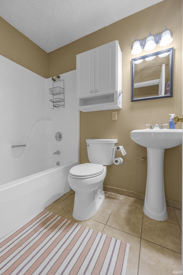 541 Genevieve Ave, Jasper, IN 47546 - bathroom featuring tile patterned floors, toilet, a textured ceiling, baseboards, and washtub / shower combination