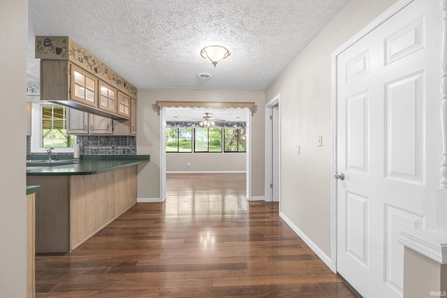 541 Genevieve Ave, Jasper, IN 47546 - kitchen with dark countertops, dark wood-type flooring, a sink, backsplash, and baseboards