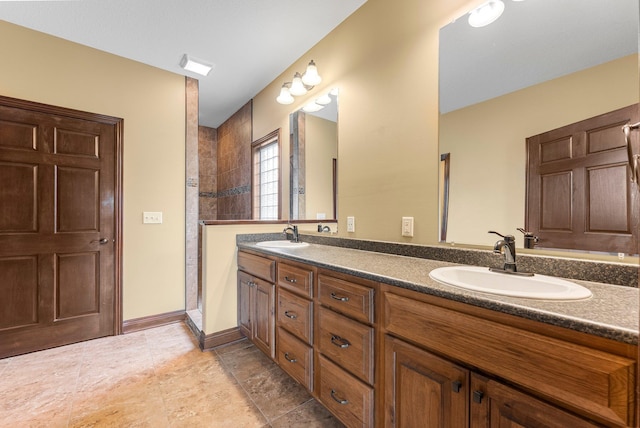 bathroom with tiled shower and double vanity