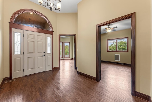 foyer entrance with a chandelier, healthy amount of natural light, dark wood-type flooring, and baseboards