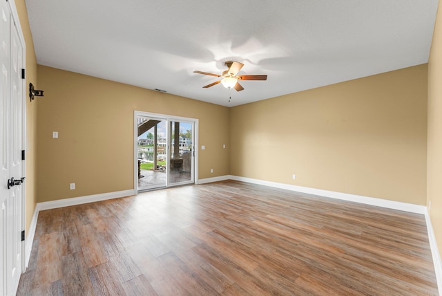 empty room featuring ceiling fan, light wood-style flooring, and baseboards