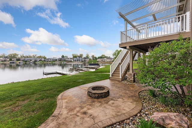 view of patio / terrace with a fire pit, a boat dock, stairs, a residential view, and a deck with water view