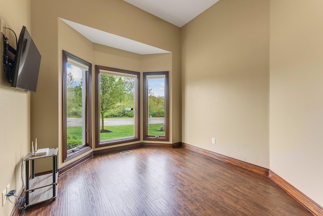 empty room featuring wood finished floors and baseboards