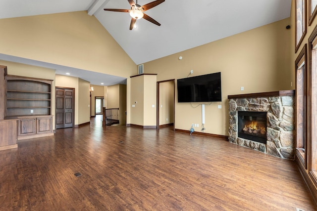 unfurnished living room with ceiling fan, a fireplace, wood finished floors, high vaulted ceiling, and beam ceiling