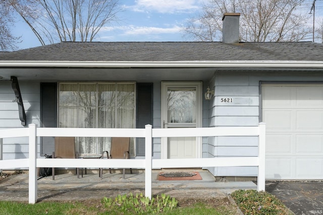 5621 Council Ring Blvd, Kokomo, IN 46902 - entrance to property with covered porch, roof with shingles, a chimney, and a garage
