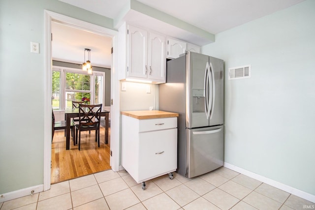 423 N Esther St, South Bend, IN 46617 - kitchen with stainless steel fridge, white cabinetry, butcher block countertops, baseboards, and light tile patterned floors