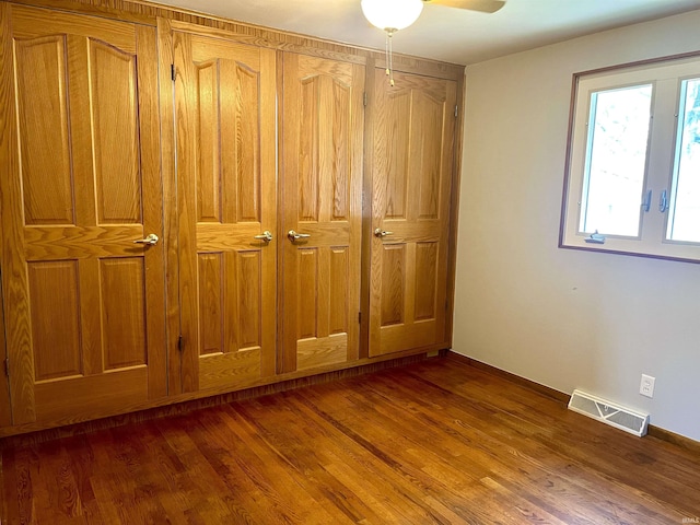 unfurnished bedroom featuring dark wood-style floors and ceiling fan