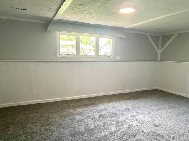 below grade area with carpet, baseboards, and a textured ceiling
