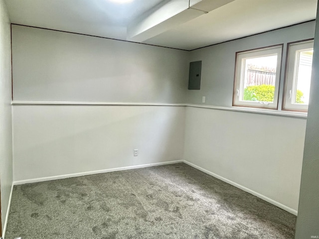 carpeted empty room featuring baseboards and electric panel