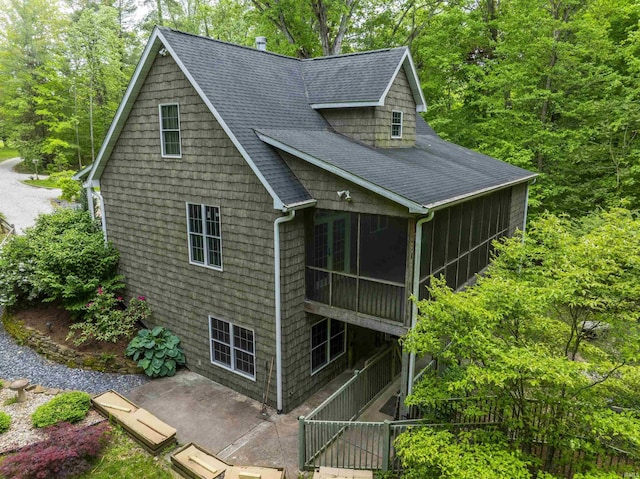 6015 E State Road 46, Bloomington, IN 47401 - view of side of property with a sunroom, roof with shingles, and a patio area