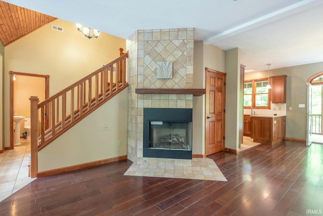 6015 E State Road 46, Bloomington, IN 47401 - unfurnished living room featuring vaulted ceiling, stairs, wood finished floors, and baseboards