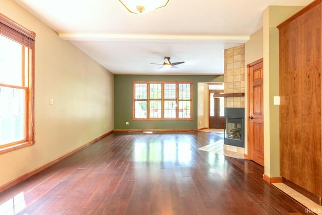 6015 E State Road 46, Bloomington, IN 47401 - unfurnished living room featuring a tile fireplace, wood finished floors, ceiling fan, and baseboards