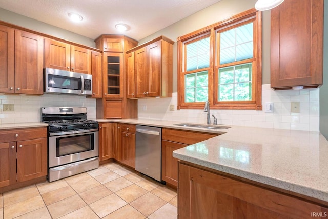 6015 E State Road 46, Bloomington, IN 47401 - kitchen with stainless steel appliances, a sink, tasteful backsplash, and brown cabinets