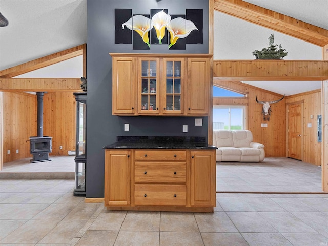 4038 Fahlsing Rd, Woodburn, IN 46797 - kitchen featuring open floor plan, wooden walls, vaulted ceiling, light tile patterned floors, and glass insert cabinets