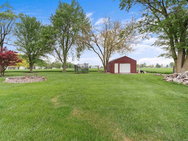 4038 Fahlsing Rd, Woodburn, IN 46797 - view of green lawn featuring a trampoline, an outdoor structure, and a garage