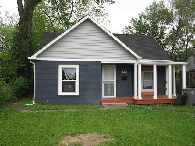 3644 N Parker Ave, Indianapolis, IN 46218 - bungalow-style house with brick siding, a porch, a front lawn, and a shingled roof