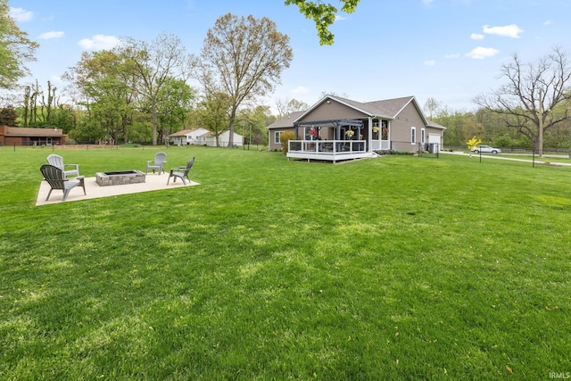 rear view of property featuring an outdoor fire pit, a patio area, and a deck