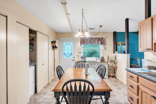 9126 Redfield Dr, Fort Wayne, IN 46819 - dining space featuring stone finish floors, a chandelier, and washer / clothes dryer