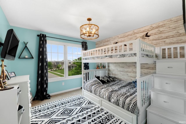 bedroom featuring a chandelier, baseboards, and light colored carpet