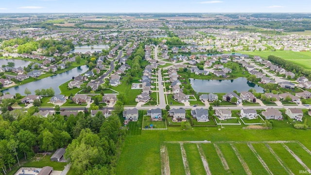 aerial view of property and surrounding area featuring a large body of water and nearby suburban area