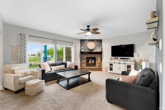 carpeted living area with a ceiling fan and a fireplace