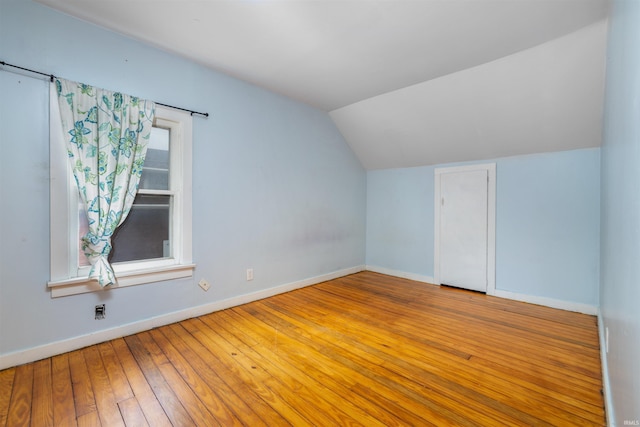 bonus room featuring vaulted ceiling, baseboards, and hardwood / wood-style floors