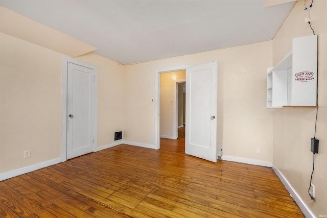 unfurnished bedroom featuring wood finished floors and baseboards