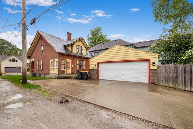 view of front of home with brick siding, fence, and a garage