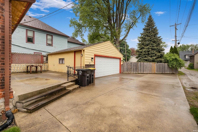 view of property exterior with fence, an outdoor structure, a shingled roof, and a detached garage