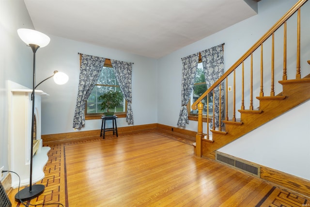 entryway with wood-type flooring, plenty of natural light, and stairs