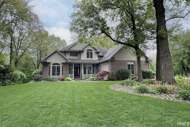 craftsman-style home featuring a porch, a front lawn, and brick siding