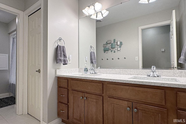 full bath featuring double vanity, tile patterned flooring, and a chandelier